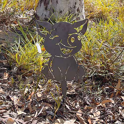 Baby Pig Cartoon Metal Garden Art in Bush Setting